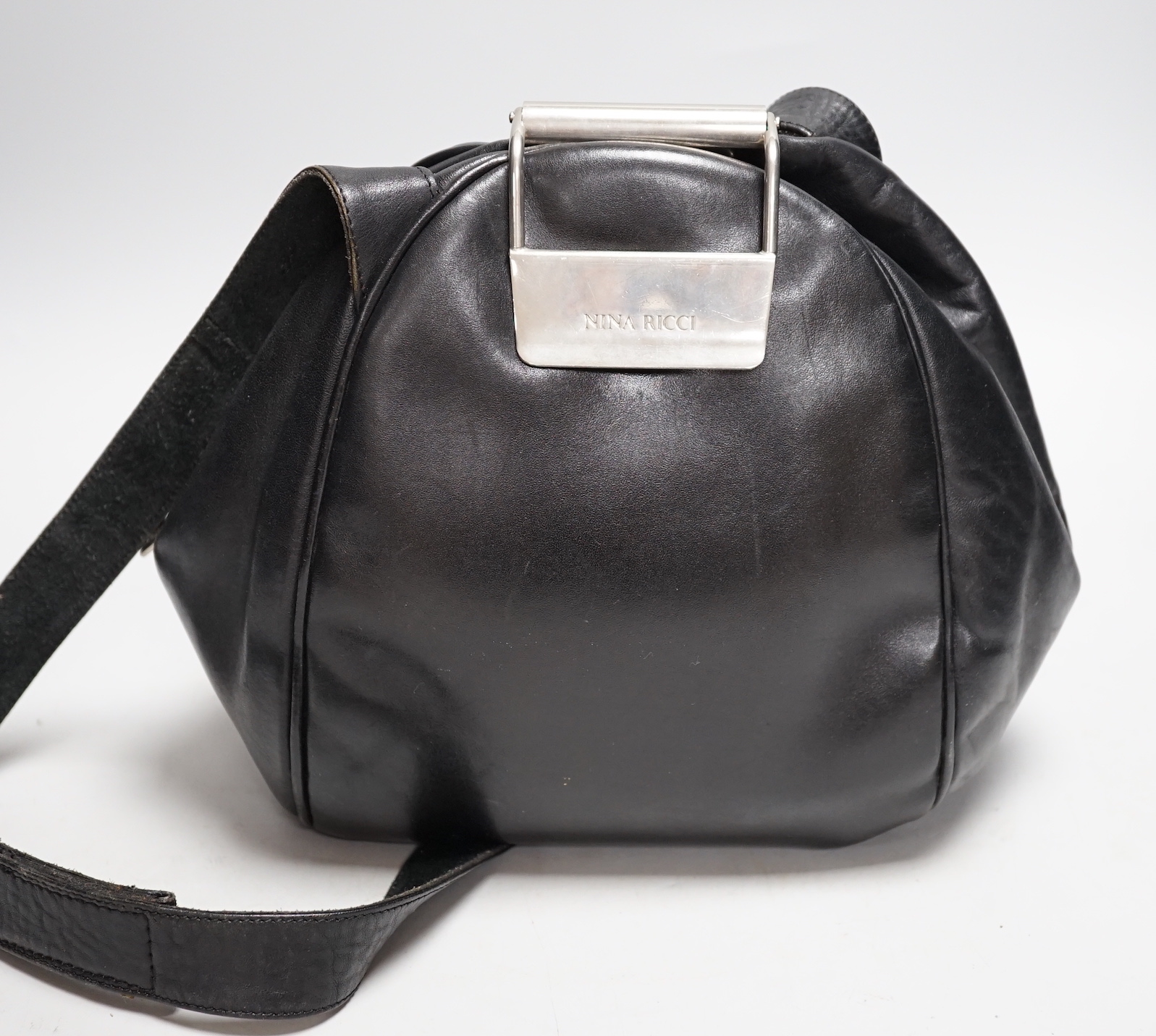 A Nina Ricci black leather shoulder bag with large metal clasp, engraved Nina Ricci, circa 1970's, approx. 23cm high